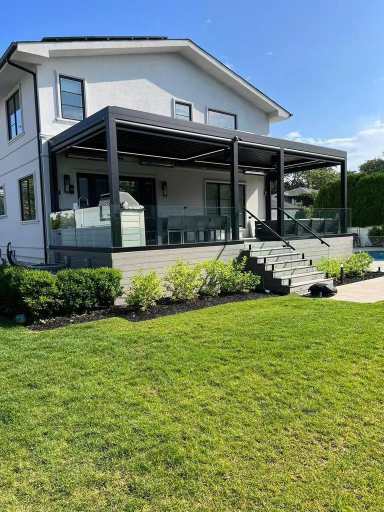 Black aluminum pergola over patio with glass railings