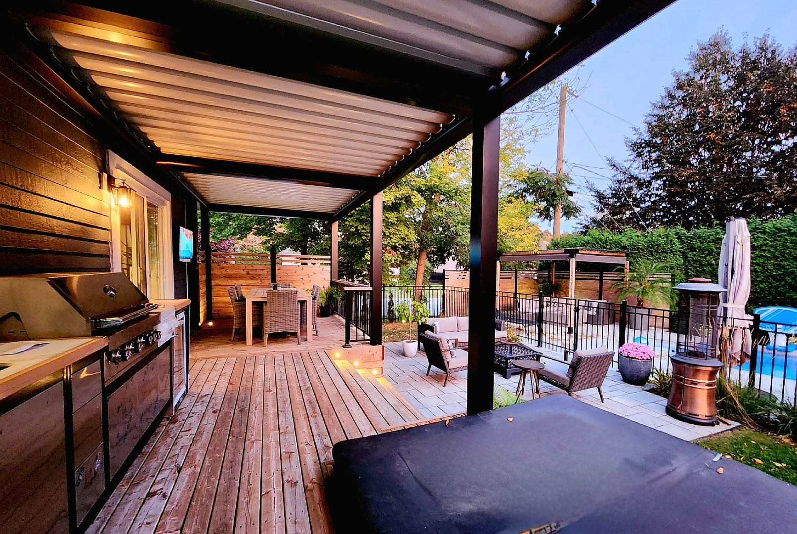 Pergola with outdoor kitchen and dining at sunset